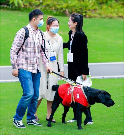 邹时勇(左一)和导盲犬六六参加华为开发者大会